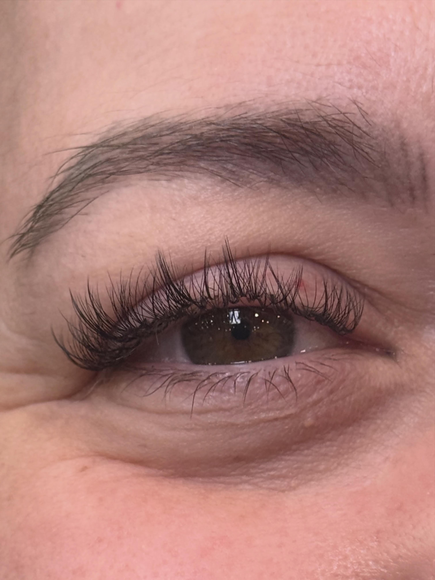 Custom lash extension set, close-up of a hazel eye