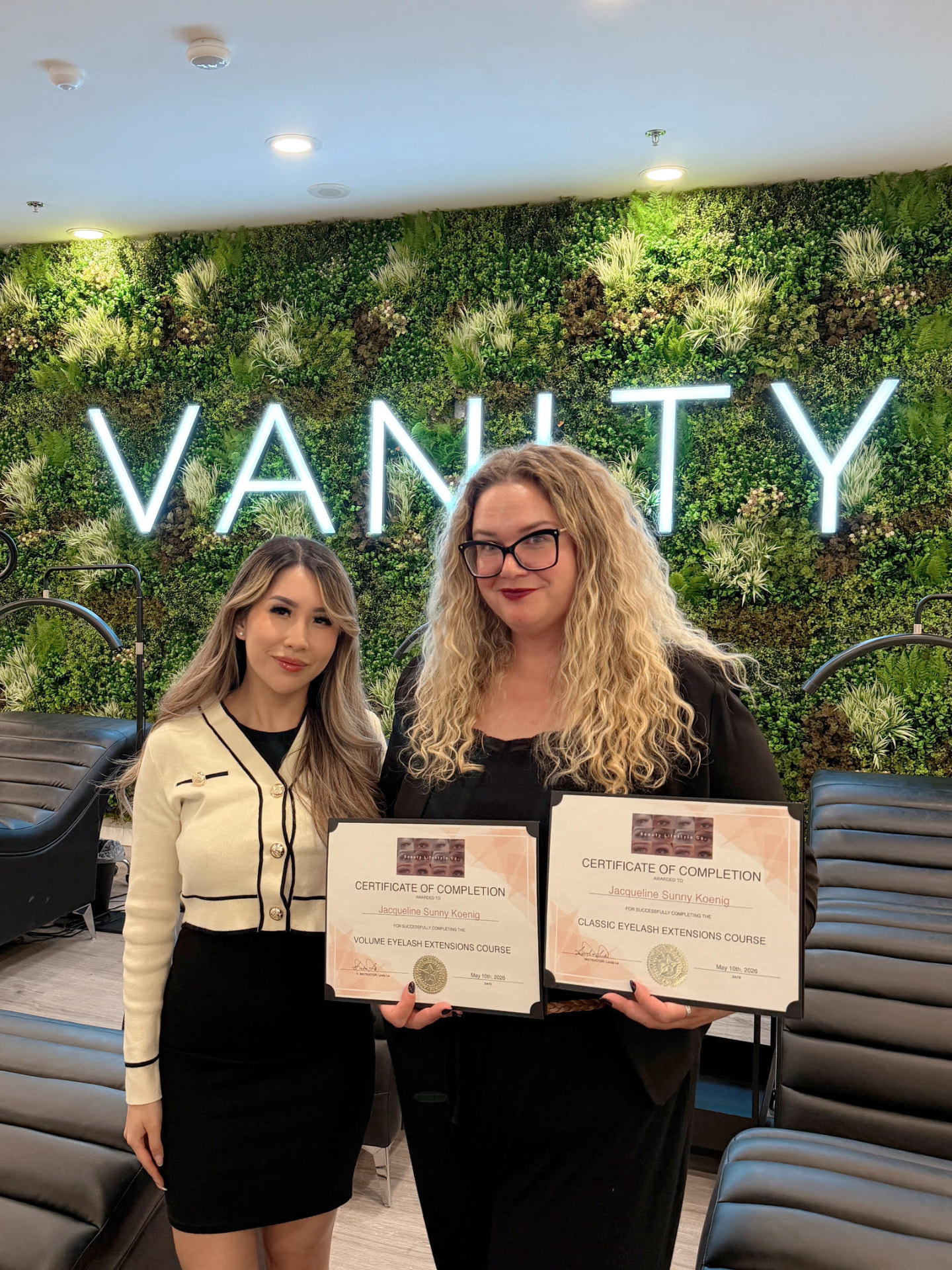 Jacqueline with her lash instructor, holding her Classic and Volume eyelash extension certificates